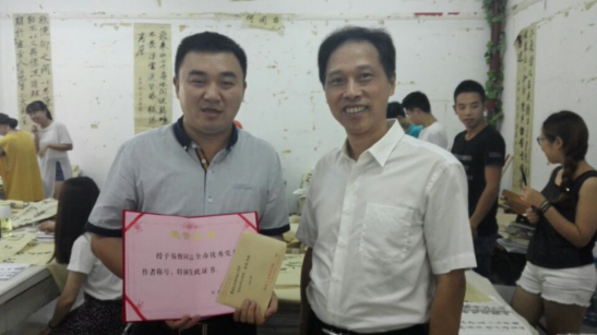 學(xué)校黨委副書記劉鐵銘為易俊老師頒發(fā)獎金后合影