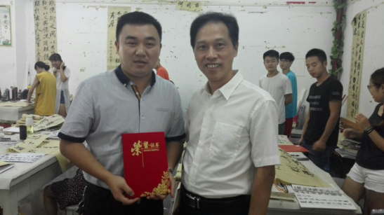 學(xué)校黨委副書記劉鐵銘為易俊老師頒發(fā)證書后合影